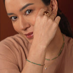 Model wearing vibrant tsavorite jewelry with 18K gold accents, showcasing a minimalist and elegant style.