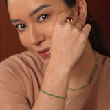 Model wearing vibrant tsavorite jewelry with 18K gold accents, showcasing a minimalist and elegant style.