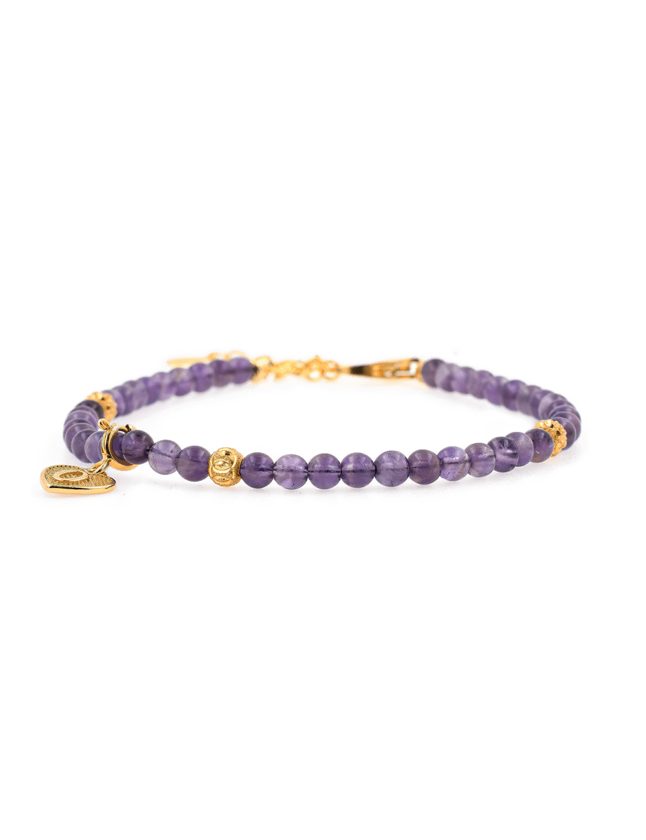 Amethyst dainty bracelet with gold spacer beads and heart charm, symbolizing love and emotional balance.