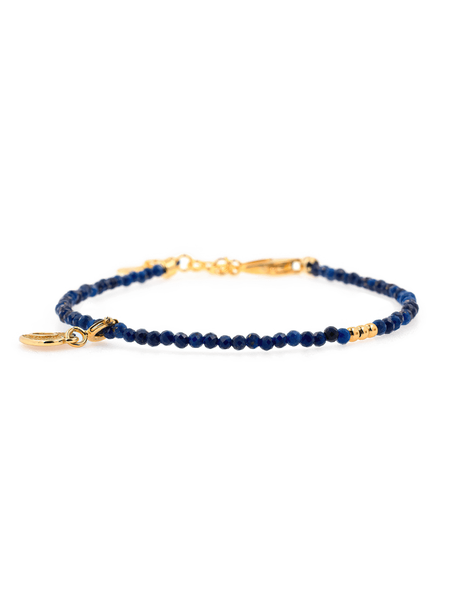 Lapis Lazuli faceted bracelet with gold spacer and heart charm, symbolizing love and spiritual insight.
