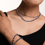 Woman wearing a stunning Tanzanite necklace, showcasing its spiritual energy and calming beauty.