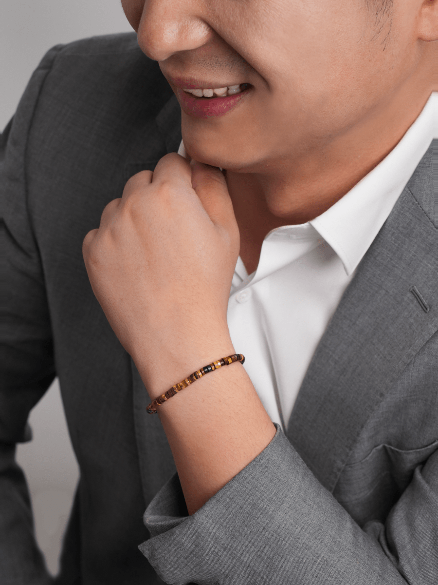 Man wearing a Tiger's Eye and gold-plated sterling silver faceted bracelet, showcasing elegance and confidence.