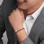 Man wearing a Tiger's Eye and gold-plated sterling silver faceted bracelet, showcasing elegance and confidence.