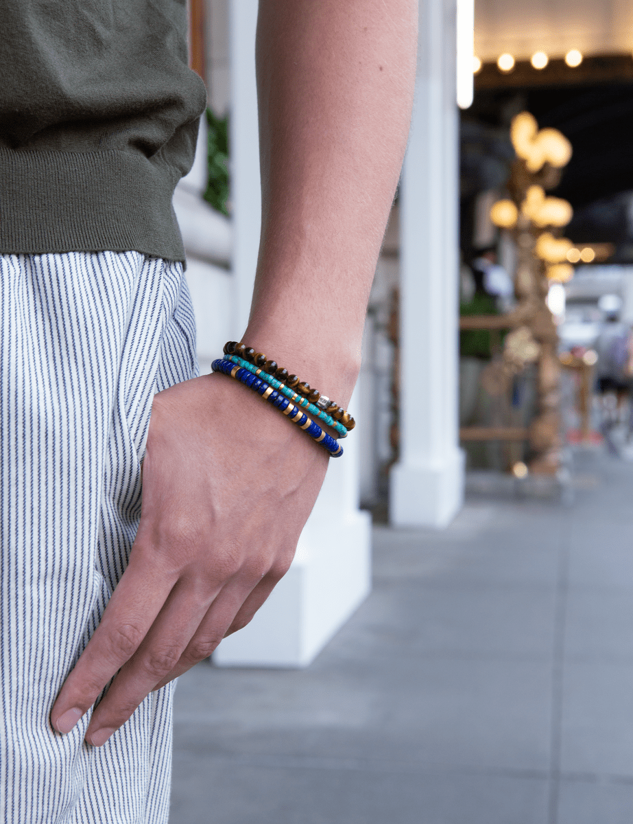 Man wearing tiger eye bracelet with silver spacer beads, showcasing a stylish accessory for confidence and focus.