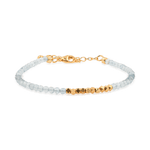 Dainty aquamarine bracelet with gold spacer beads, symbolizing clarity and resilience in modern design.