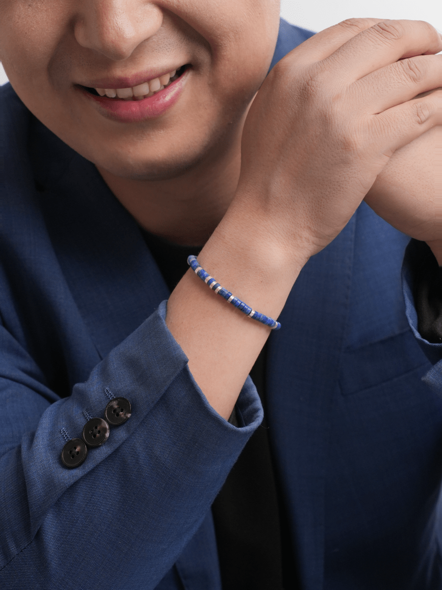 Man wearing Wisdom Lapis Lazuli & Sterling Silver Faceted Bracelet, showcasing its elegant design and vibrant blue beads.