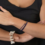 Wood and lapis lazuli bracelet with silver spacer beads worn on model's wrist.